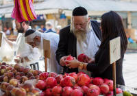 Buying pomegranates, a traditional Rosh Hashana food, at Jerusalem's Mahane Yehuda market. (Noam Revkin Fenton/Flash90)