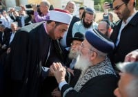 Jerusalem's chief rabbi Shlomo Amar shakes hands with  Imam Assi as leaders from the Christian and Muslim community come to show their support outside the Har Nof synagogue where the massacre took place.