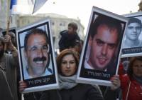 Demonstrators carry pictures of victims killed by Palestinian terrorists. (Hadas Parush/Flash90)