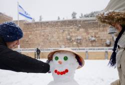 Women build a snowman at the Western Wall. (Mendy Hechtman/FLASH90)