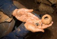 Agate stones that were part of a string of beads and the Hellenistic oil lamp in which the stones were kept. (Shmuel Magal/IAA)