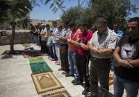 Palestinian men pray.