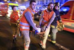 A woman is evacuated from the Bataclan theater after an Islamic terror attack in Paris. (AP/Jerome Delay)