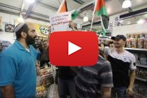 Foreign and Palestinian activists hold Palestinian flags as they march through an Israeli supermarket