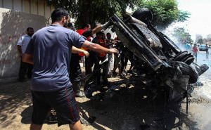Gazans inspect a vehicle destroyed by an Israeli air strike on Aug. 24. (Photo: Emad Nassar/Flash90)