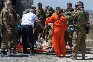 Medics treat a wounded Israeli soldier who was injured by flying shrapnel from Syrian  Golan Heights that landed on the Israeli side. (Photo: Flash90)
