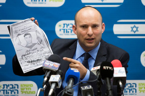 Economy Minister Naftali Bennett on Oct. 27, 2014, holds photo of terrorist who killed a woman and an infant.  He now demands an apology from American official who cursed the Israeli PM. (Photo: Yonatan Sindel/Flash90)