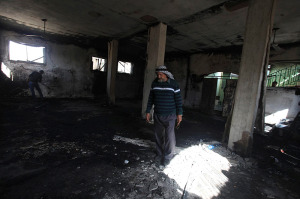 An Arab inspects a mosque that was burned Wednesday morning near the city of Shilo. (Photo: STR/Flash90)