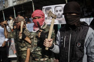 Masked Palestinians hold axes and a gun to celebrate the Jerusalem synagogue attack. (Abed Rahim Khatib/Flash90)