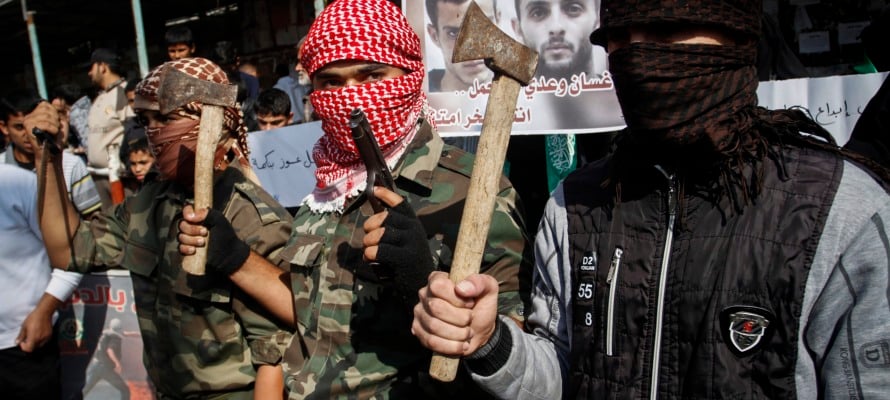 Masked Palestinians hold axes and a gun to celebrate the Jerusalem synagogue attack. (Abed Rahim Khatib/Flash90)