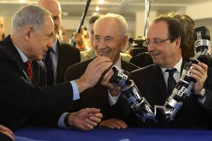 French President Hollande (R), Prime Minister Netanyahu (L) and former President Peres look at a French-Israeli technology innovation summit in Tel Aviv last year. (Photo: Kobi Gideon/GPO)