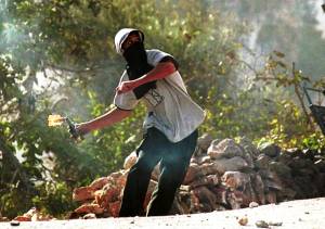 A Palestinian terrorist throws a firebomb at Israeli security forces. (Yossi Zamir/Flash90)