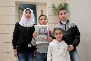 Los familiares de Ibrahim Akkari mantienen su imagen como un mártir después de ser baleado tras su volante de su coche contra un grupo de personas en una estación de tren ligero de Jerusalén. 