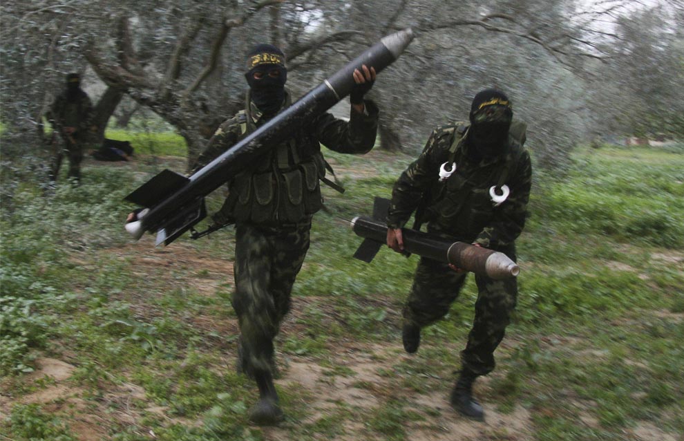 Masked Palestinian terrorists from Islamic Jihad carry homemade rockets before firing them into Israel. (Photo: Amir Farshad Ebrahimi / Flickr)