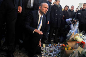 Ministro de Economía, Naftali Bennett enciende una vela fuera del supermercado kosher en París, donde cuatro hombres judíos fueron asesinados por los terroristas afiliados estatales islámicos.  (Foto: Serge Attal / Flash90)