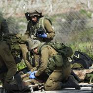 IDF troops carrying an injured soldier after an IDF patrol came under attack from Hezbollah terrorists in the Mount Dov region along the Israeli border with Lebanon on January 28, 2015. (Basal Awidat/Flash 90)