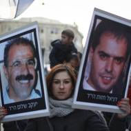Demonstrators carry pictures of victims killed by Palestinian terrorists. (Hadas Parush/Flash90)