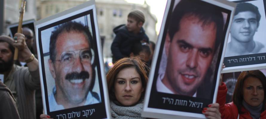 Demonstrators carry pictures of victims killed by Palestinian terrorists. (Hadas Parush/Flash90)