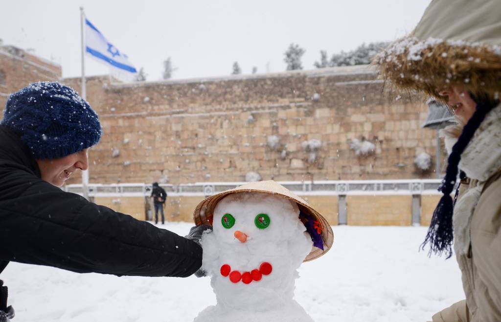 Women build a snowman at the Western Wall. (Mendy Hechtman/FLASH90)