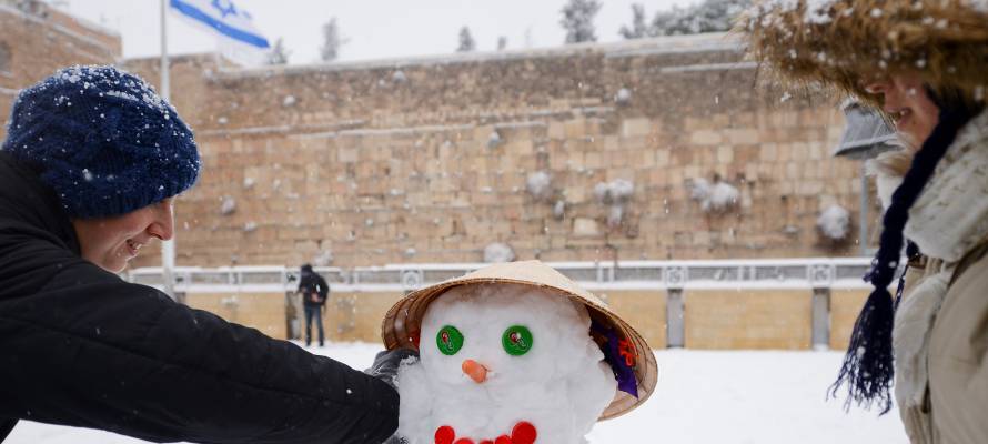 Women build a snowman at the Western Wall. (Mendy Hechtman/FLASH90)