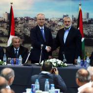 Palestinian Prime Minister Rami Hamdallah shakes hands with senior Hamas leader Ismail Haniyeh in October 2014.