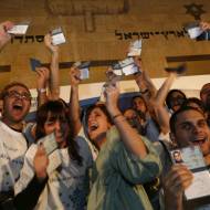 Young French adults hold up their new Israeli Id's after emigrating to Israel.