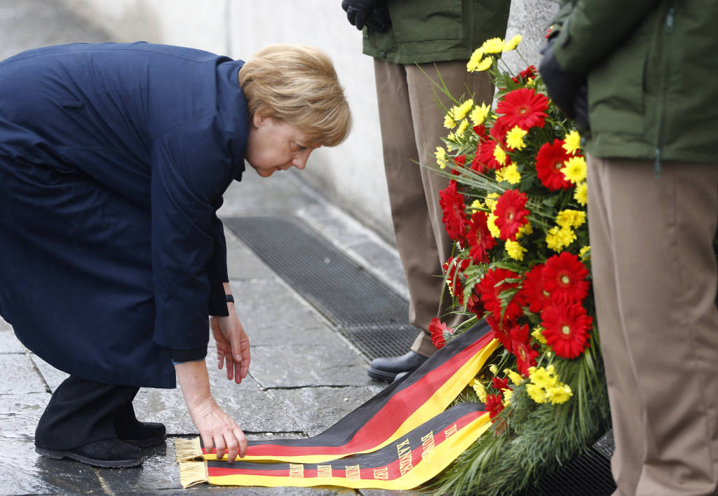 German Chancellor Angela Merkel lays a wreath at Dachau