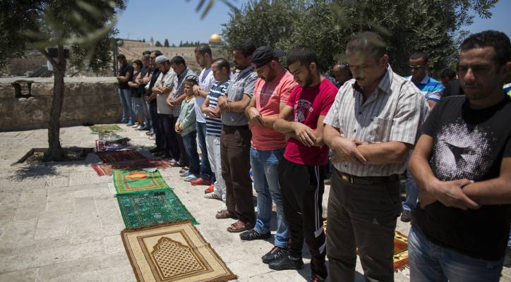 Palestinian men pray.