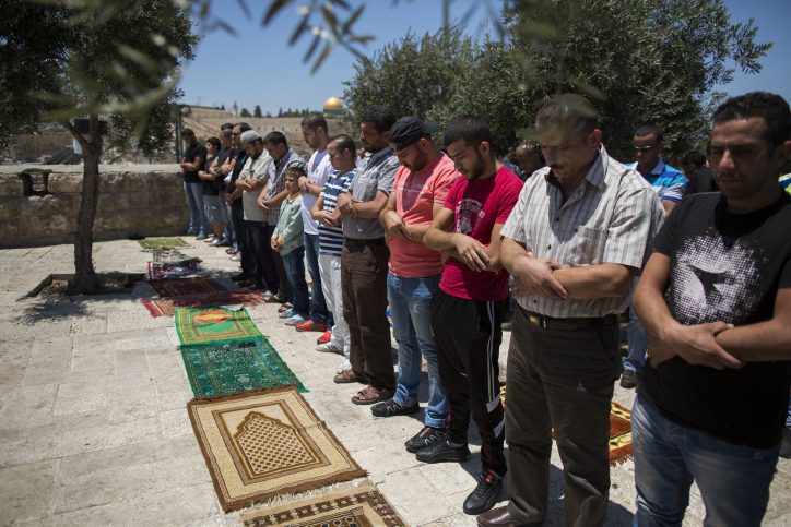 Palestinian men pray.