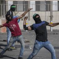Palestinians throw rocks at Israeli border police.