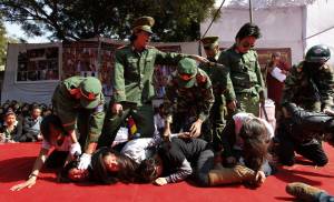 Exiled Tibetans dressed as Chinese soldiers act as though they are abusing Tibetans at a in New Delhi, India, in 2012. (AP/Saurabh Das)