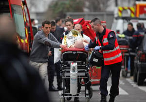  An injured person is rushed to hospital in Paris following Islamic terror attack at Charlie Hebdo headquarters in Jan 2015. (AP/Thibault Camus)