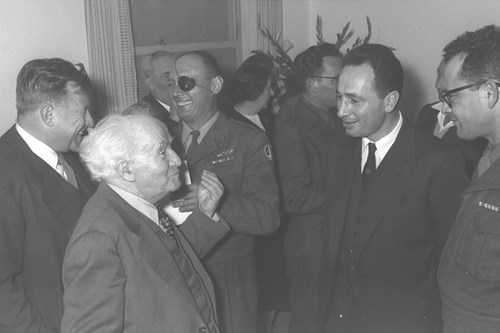 1958 - MR. TEDDY KOLLEK, BEHIND P.M. DAVID BEN GURION (L), R/A MOSHE DAYAN, MR. SHIMON PERES (2ND R) CHIEF OF STAFF HAIM LASKOV AT THE CEREMONY MARKING HIS APPOINTMENT. (GPO)