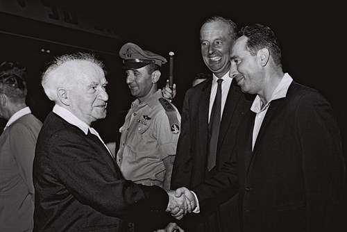 1962 - MR. SHIMON PERES, DEPUTY MINISTER OF DEFENCE GREETING P.M. DAVID BEN GURION ON HIS RETURN FROM HIS SCANDINAVIAN TOUR AT LYDDA AIRPORT. (GPO)