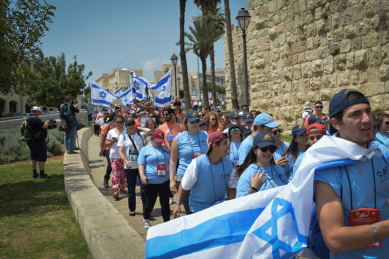 Israeli youth march in Jerusalem with flags