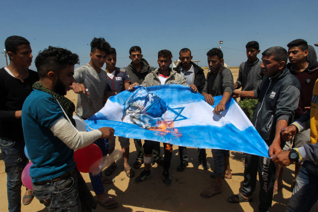Palestinians burn an Israeli flag near the Gaza border. (Abed Rahim Khatib/Flash90)