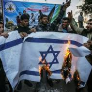 Palestinians burn an Israeli flag