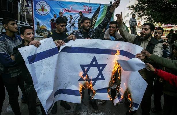 Palestinians burn an Israeli flag
