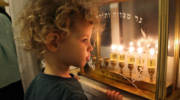 An Israeli boy looking at Chanukah candles. (Gershon Elinson/Flash90)