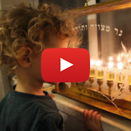 An Israeli boy looking at Chanukah candles. (Gershon Elinson/Flash90)