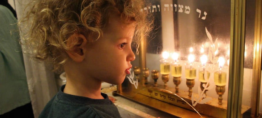 An Israeli boy looking at Chanukah candles. (Gershon Elinson/Flash90)