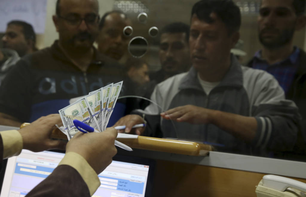 An employee of the Hamas terror group receives a salary payment  financed by millions of dollars in aid from Qatar. (AP Photo/Adel Hana)