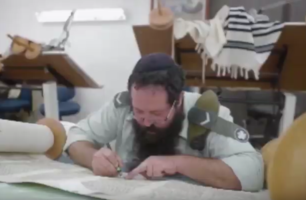 An Army rabbi writes a Torah scroll. (screenshot)