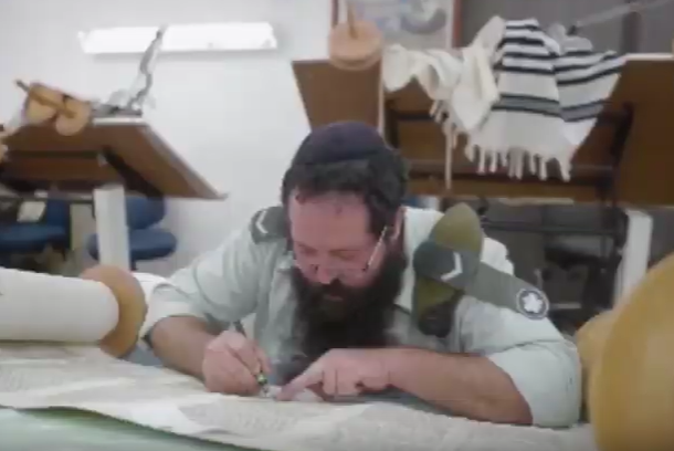 An Army rabbi writes a Torah scroll. (screenshot)