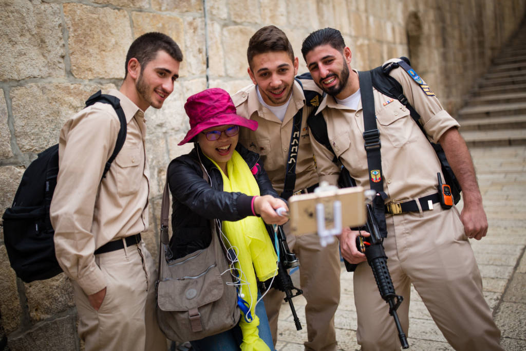 A tourist seen taking selfies with soldiers in Jerusalem's Old City. (Corinna Kern/FLASH90)