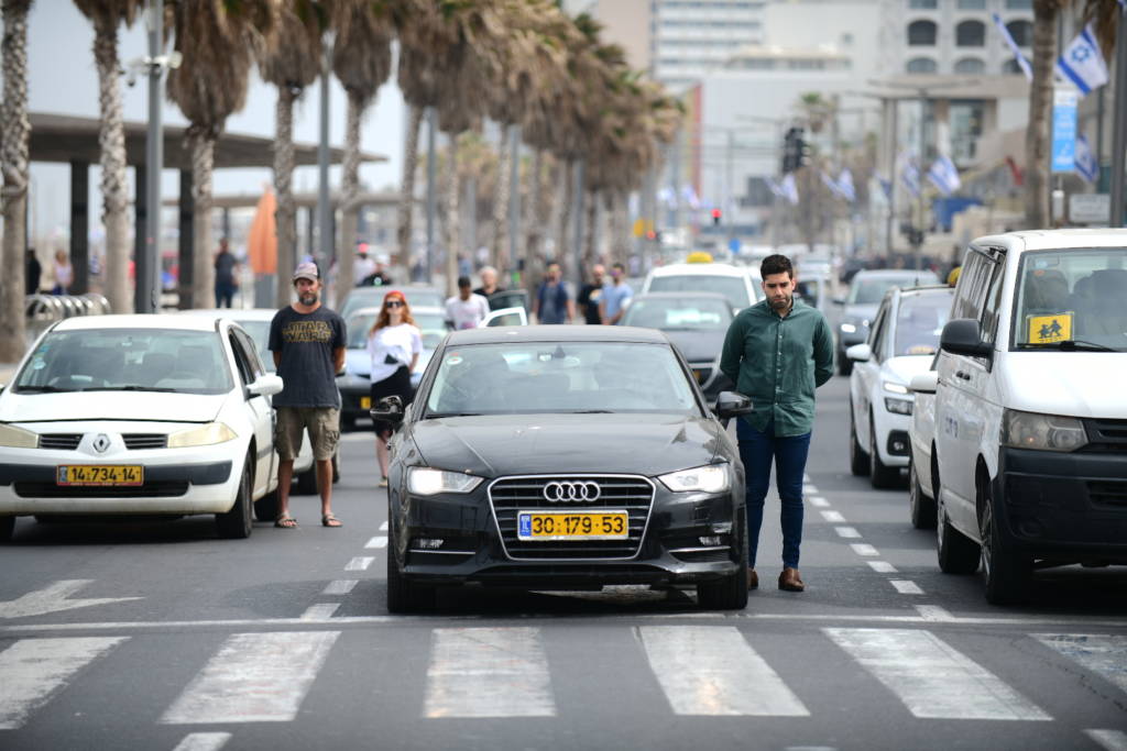 People stand still in Tel Aviv, as a two-minute siren is sounded. (Tomer Neuberg/Flash90)