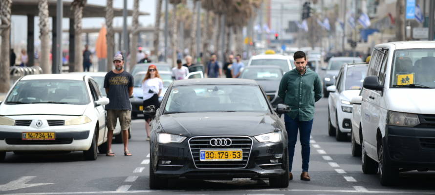 People stand still in Tel Aviv, as a two-minute siren is sounded. (Tomer Neuberg/Flash90)