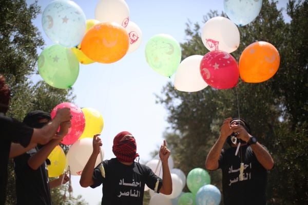 Palestinians prepare arson balloons to attack Israel. (Hassan Jedi/Flash90)