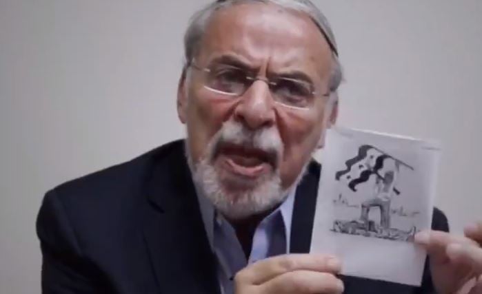 Dov Hikind holds cartoon by Holocaust denier