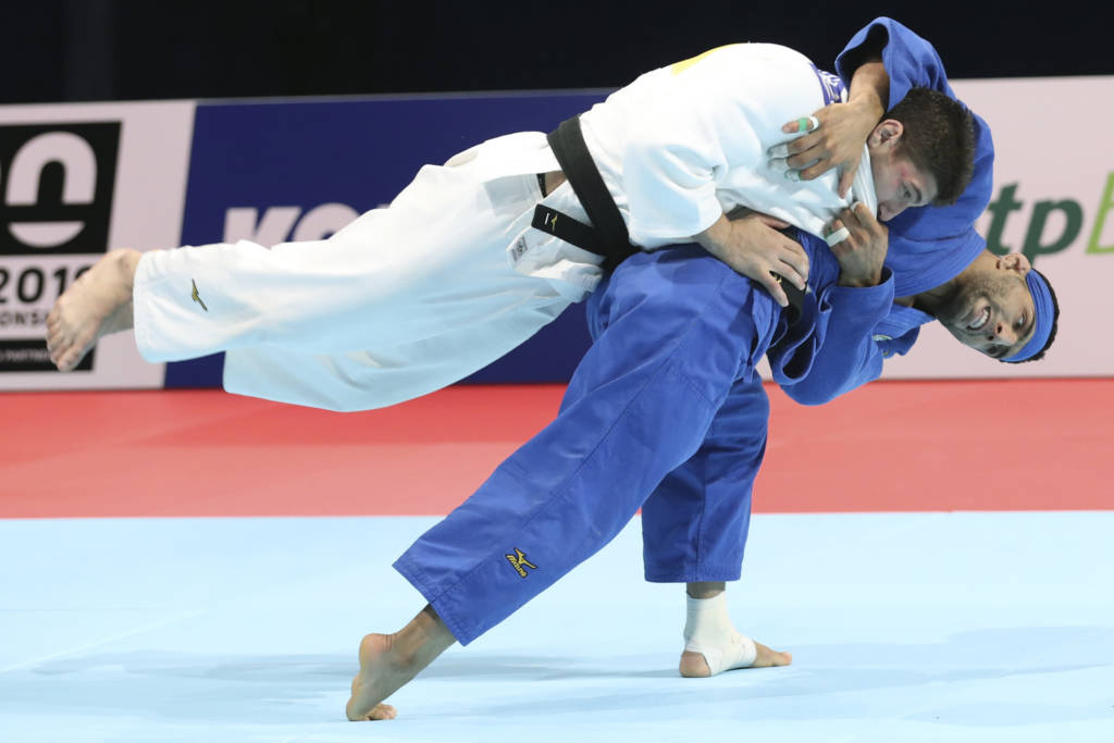 Luka Maisuradze of Georgia, top, competes against Saeid Mollaei of Iran during a men's -81 kilogram bronze medal match of the World Judo Championships in Tokyo, Wednesday, Aug. 28, 2019.